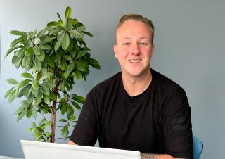 Collega Bob aan een bureau met laptop.