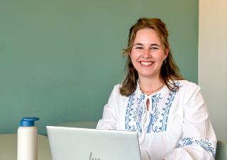 Collega Julia zit met haar laptop aan een bureau