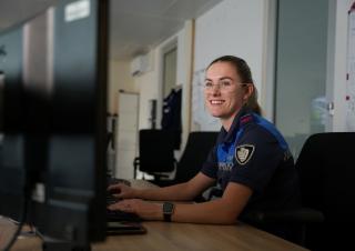 Collega Stephanie zit achter een computerscherm in de meldkamer